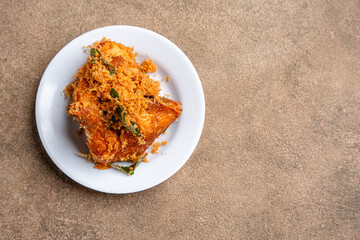 Ayam Goreng Padang. Traditional fried chicken with spice crumbs from Minangkabau, West Sumatra. served on white plate 