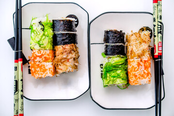Several sushi on a white plate standing on a white background
