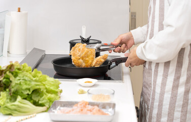 キッチンで料理を作る40代の男性