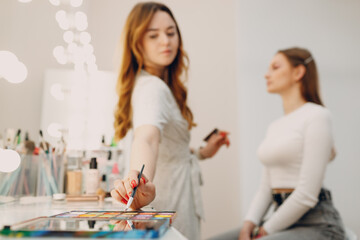 Beautiful young woman applying makeup beauty visage brush.