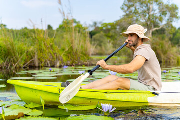Caucasian man tourist enjoy outdoor lifestyle kayaking at mangrove forest on summer vacation....