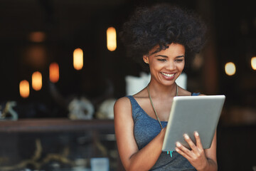 Her online orders are growing. a young woman using a digital tablet in a cafe.