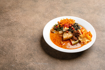Lontong sayur or vegetable rice cake is an Indonesian traditional rice dish made of pieces of lontong served in coconut milk soup with shredded chayote, tempeh, tofu, hard-boiled egg, sambal, rendang