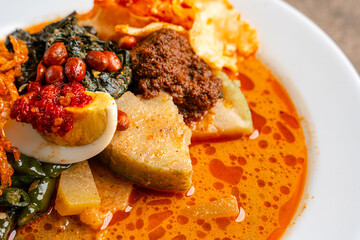 Lontong sayur or vegetable rice cake is an Indonesian traditional rice dish made of pieces of lontong served in coconut milk soup with shredded chayote, tempeh, tofu, hard-boiled egg, sambal, rendang