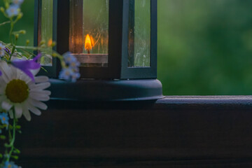 Candle lantern and spring flowers lifestyle photograph in the garden summer time