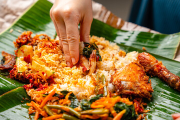 Indonesian padang food or nasi bungkus with padang fried chicken (indonesian : Ayam goreng padang)