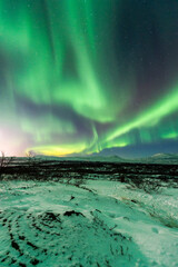 imagen de un paisaje nocturno natural nevado, con una aurora boreal en el cielo de Islandia 