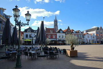 The main square Groenmarkt in Amersfoort, Utrecht, Netherlands, with historic house facades, cafe terraces and the Onze Lieve Vrouwe Toren (Church tower of our Lady) in the background