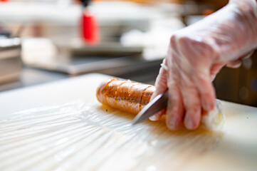 professional chef's hands making sushi roll in a restaurant kitchen