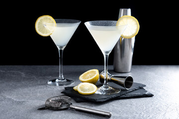 Lemon drop martini cocktail on gray stone and black background