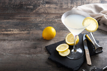 Lemon drop martini cocktail on wooden table. Copy space