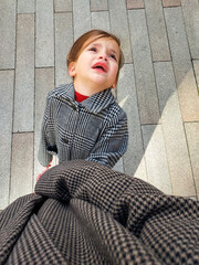 madre e hija de paseo por la ciudad, niña llorando de la mano de su madre 