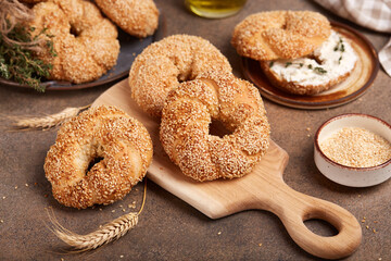 Fototapeta na wymiar Bagels with sesame seeds. Freshly baked bread buns from yeast dough. 