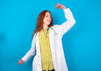 Profile photo of excited young doctor woman wearing medical uniform over blue background good mood...