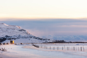 imagen de un camino nevado, entre un paisaje blanco por la nieve y el cielo azul con algunas nubes 