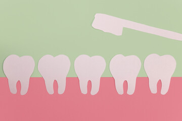 Paper toothbrush over paper teeth. Dental care concept
