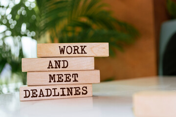 Wooden blocks with words 'Work and meet deadlines'.