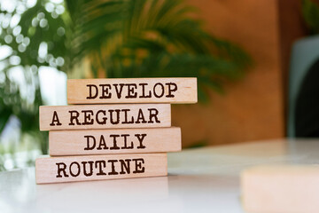 Wooden blocks with words 'Develop a regular daily routine'.