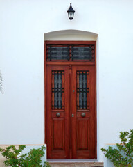 Obraz premium A whitewashed wall house with a brown wood door. Travel to Milos island, Greece.