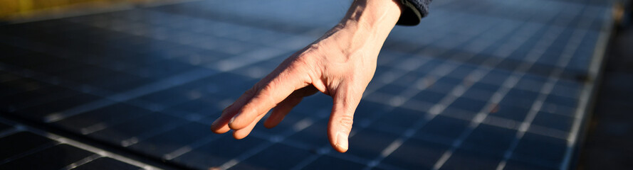 Banner für Solaranlagen: Handwerker Hand zeigt auf Solar Panels 2023. Sonnenstrom durch günstigen KfW Kredit von der Bank nachhaltig erzeugen