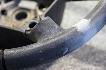 A close-up photo of a fragment of a car steering wheel being repaired with putty, showcasing the precision and attention to detail of car repair services.