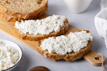 Bread with curd cheese on wooden board
