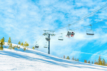 Ski Lift on Snowy Mountain Slope Against Blue Sky