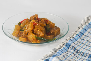 stir-fried kikil or knuckle served on a small plate isolated with a napkin on a white background