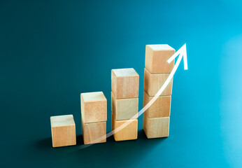 White rising up arrow draw on wooden cube blocks bar graph chart steps on blue background, minimal...