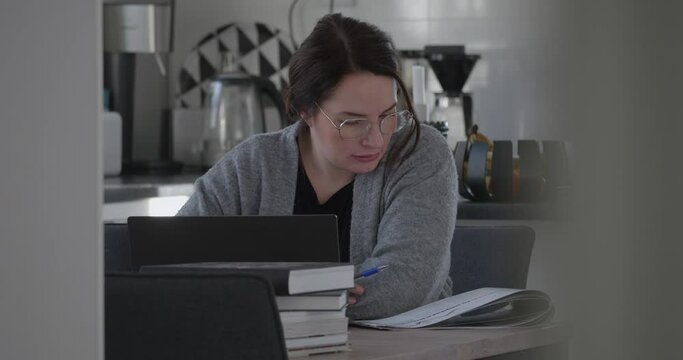 Focused adult woman studying at home