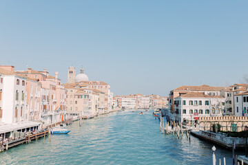 Fototapeta na wymiar The great canal flows through Venice, taking its travelers with it. Everything shines in bright sunshine and the water shines turquoise.