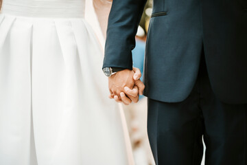 Bride and groom holding their hands during the wedding ceremony