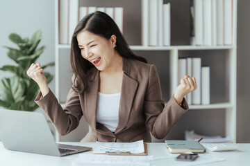 Asian businesswoman in formal suit in office happy and cheerful during using smartphone and working