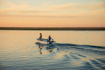 A man and a weimaraner dog on the boat at sunrise in  Faro, Algarve, Potugal