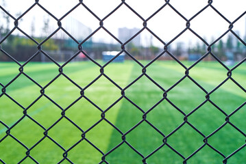 Fototapeta premium Barbed wire fence outside a football field