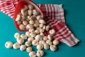 Organic Crispy Lotus pops Seeds or Phool Makhana served in a wooden bowl on background.