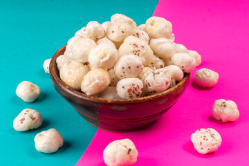 Organic Crispy Lotus pops Seeds or Phool Makhana served in a wooden bowl on background.