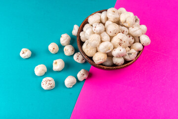 Organic Crispy Lotus pops Seeds or Phool Makhana served in a wooden bowl on background.