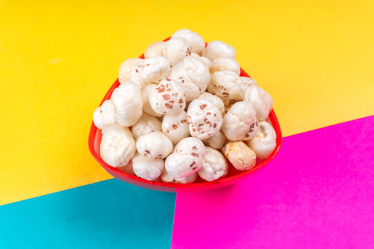 Organic Crispy Lotus pops Seeds or Phool Makhana served in a wooden bowl on background.