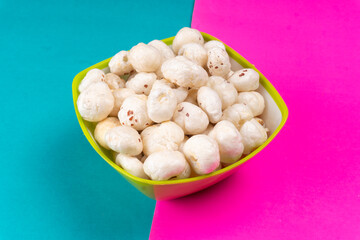 Organic Crispy Lotus pops Seeds or Phool Makhana served in a wooden bowl on background.