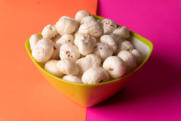 Organic Crispy Lotus pops Seeds or Phool Makhana served in a wooden bowl on background.