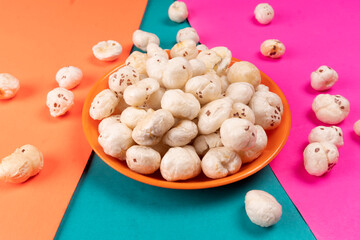 Organic Crispy Lotus pops Seeds or Phool Makhana served in a wooden bowl on background.