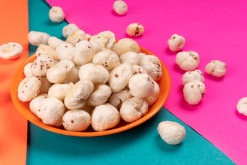 Organic Crispy Lotus pops Seeds or Phool Makhana served in a wooden bowl on background.