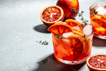 Red cocktail with Sicilian red oranges on a light background, summer concept