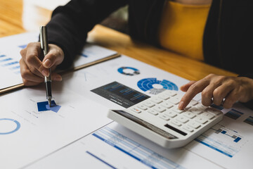 Financial accountant working on auditing and budget analysis on business reports using calculator...