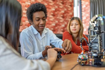 Obraz premium Teenager children learning with new innovation robotic hand interface hand control in classroom