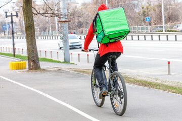 Driving a bicycle, a food delivery vehicle in an urban area.