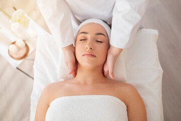 Fototapeta na wymiar Closeup Shot Of Relaxed Indian Woman Enjoying Neck Massage At Spa