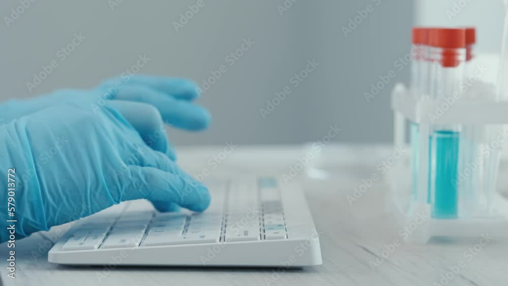 Poster a female researcher sits at a workplace in a laboratory, behind a personal computer monitor. against
