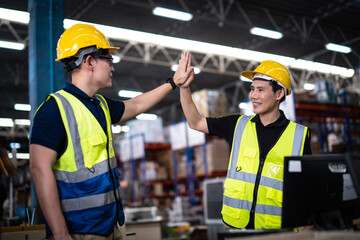 Two Asian warehouse workers showing teamwork and partnership. teamwork at warehouse storage department.